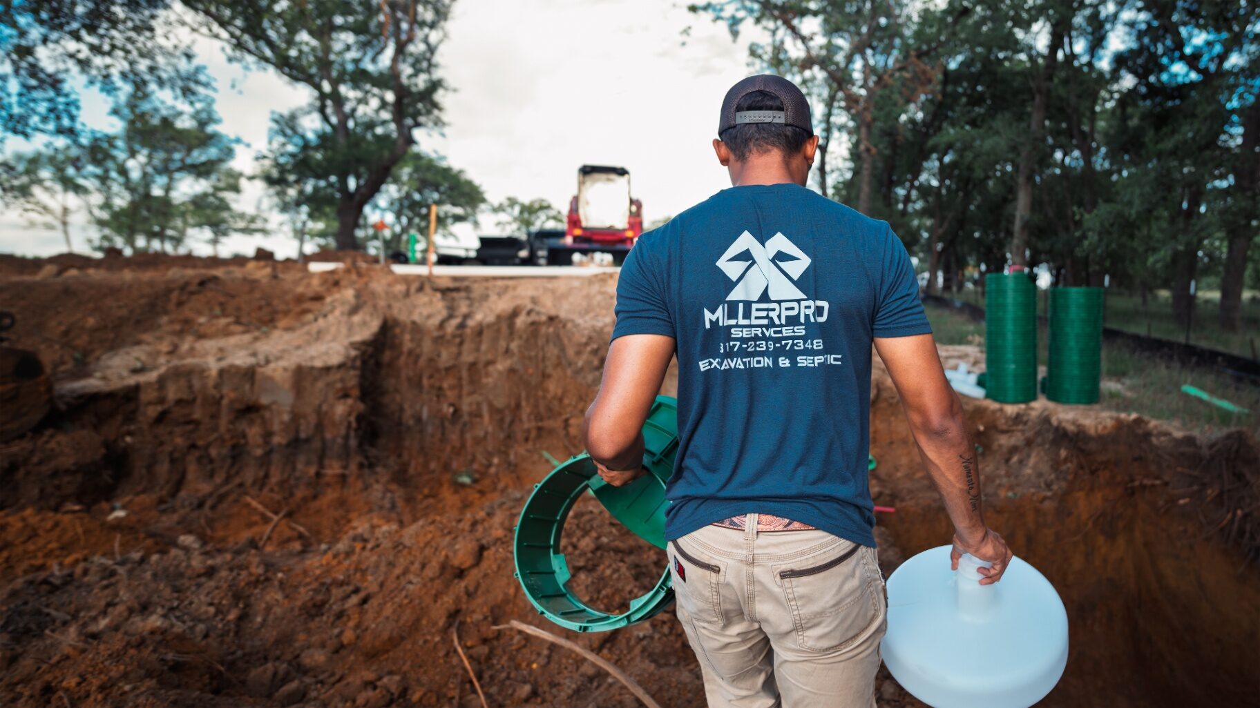 MillerPro crew member carrying septic risers to a dig site