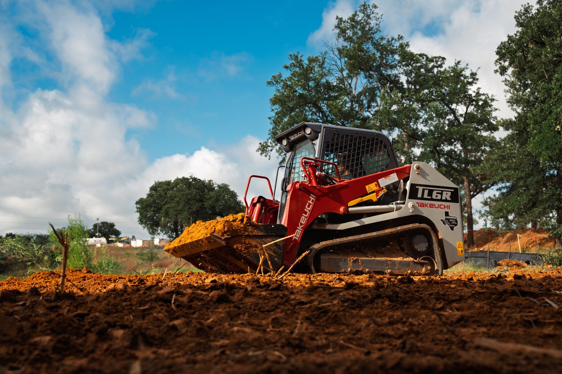 Takeuchi track loader grading a site during excavation near Burleson, Texas